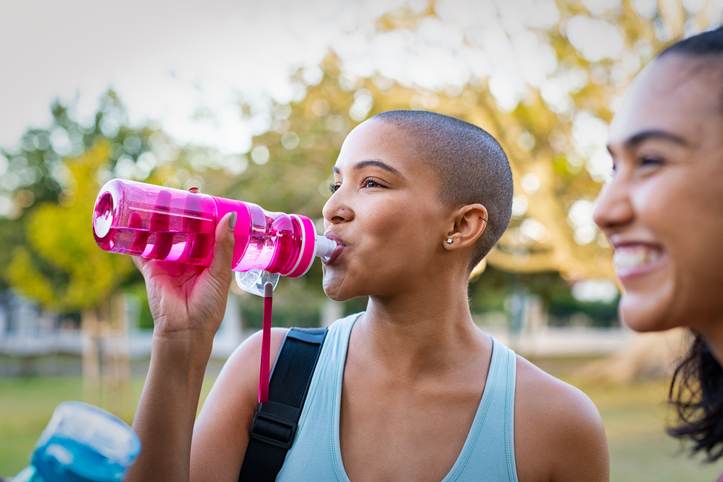 Sporty woman drinking water after exercise Sporty woman drinking water after exercise
