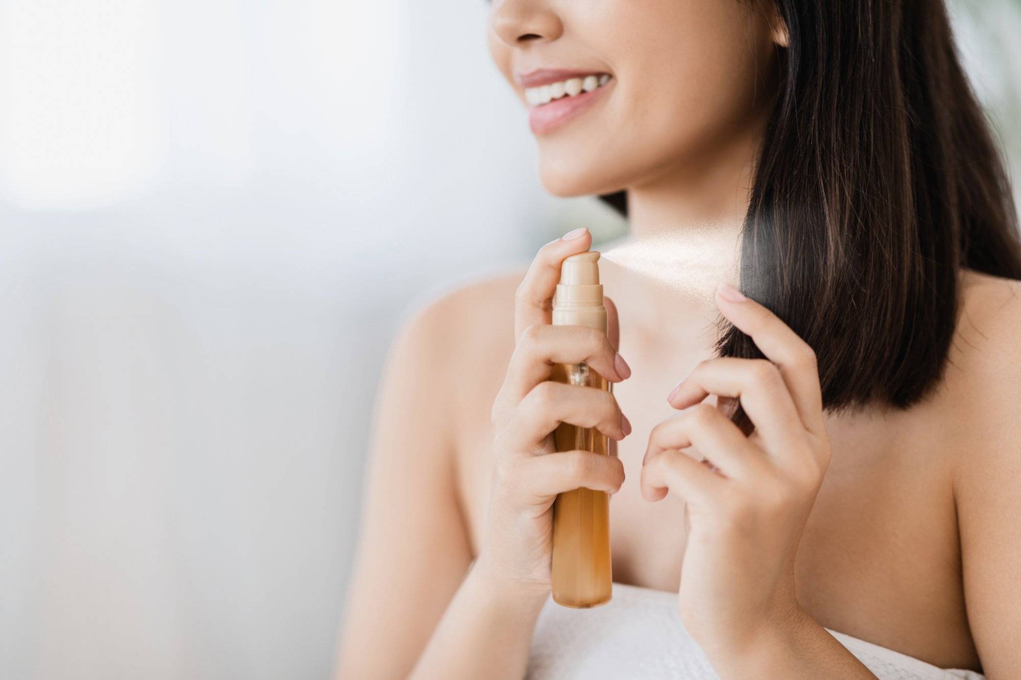 Closeup of asian girl using hair spray, copy space