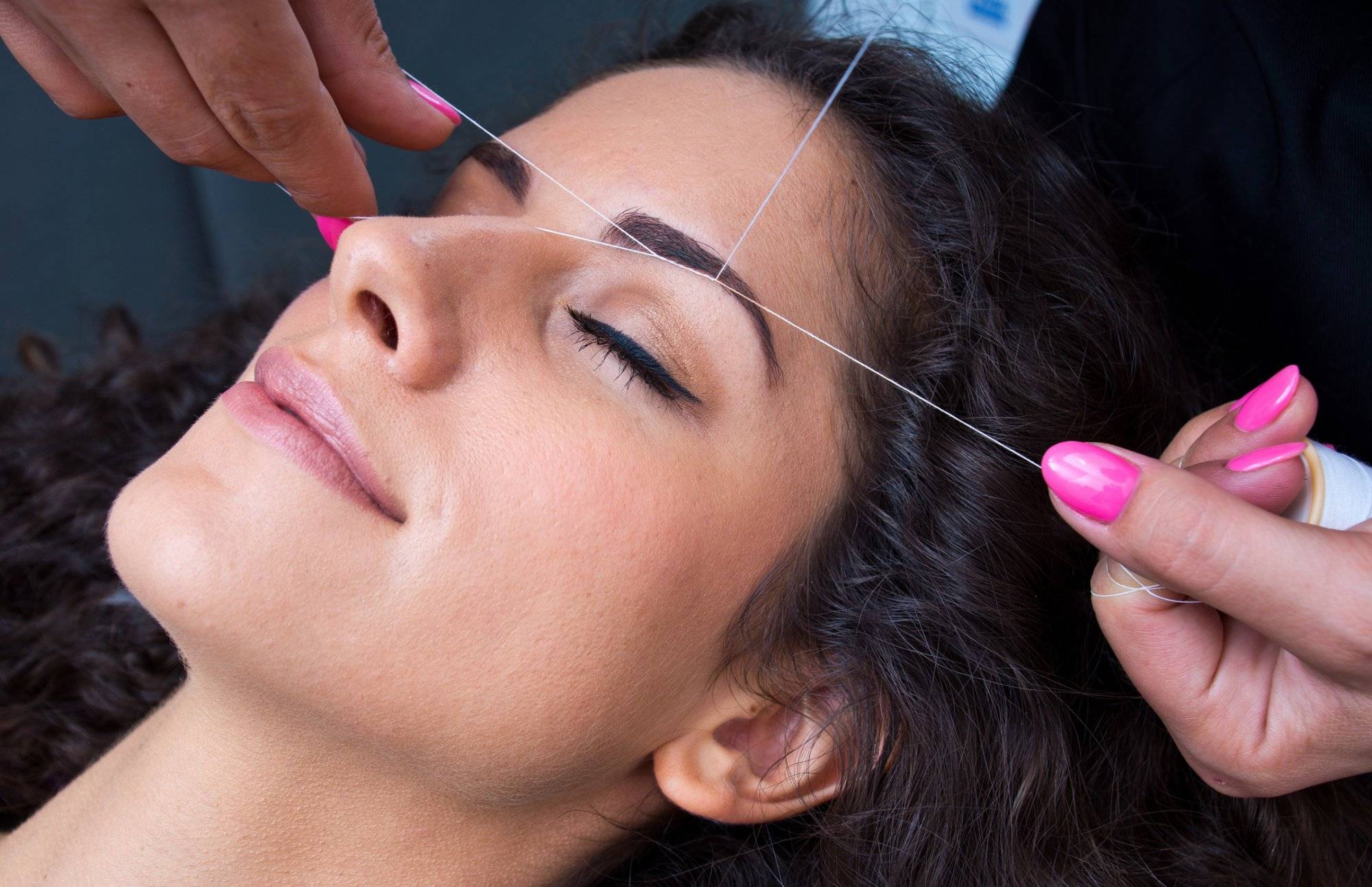 woman on facial hair removal threading procedure woman on facial hair removal threading procedure