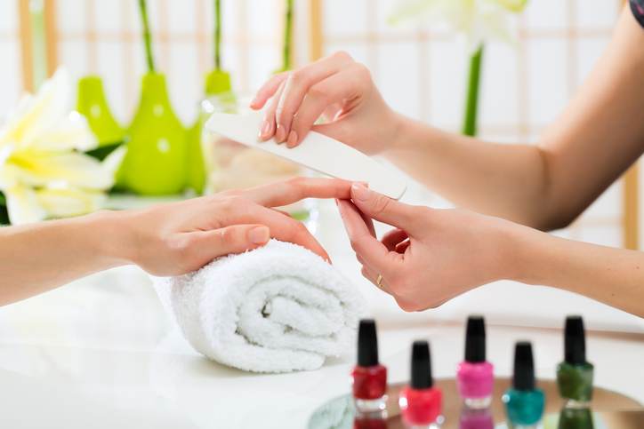 Woman in nail salon receiving manicure Woman in nail salon receiving manicure