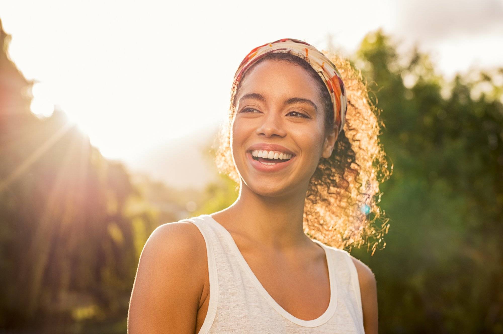 Young african woman smiling at sunset Young african woman smiling at sunset