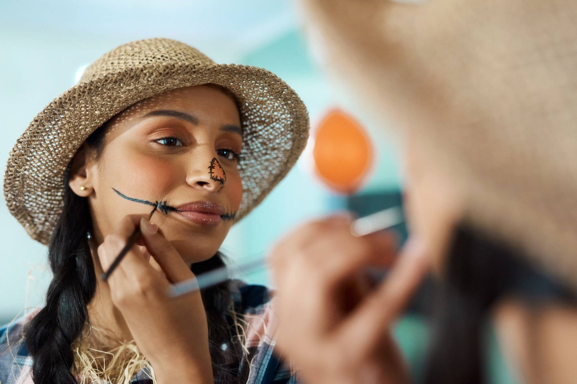 Shot of a young woman applying halloween makeup at home